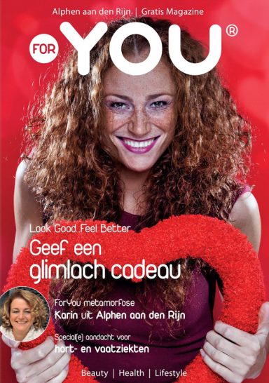 Vrouw met krullend haar houdt een grote rode ring vast, glimlachend voor een magazinecover.