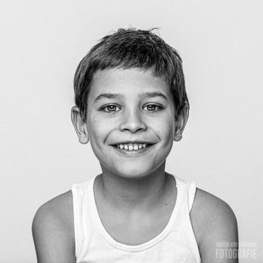 Jongeman met kort haar en een glimlach, gekleed in een witte tanktop.