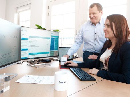 Twee mensen aan een bureau werken samen op computers.